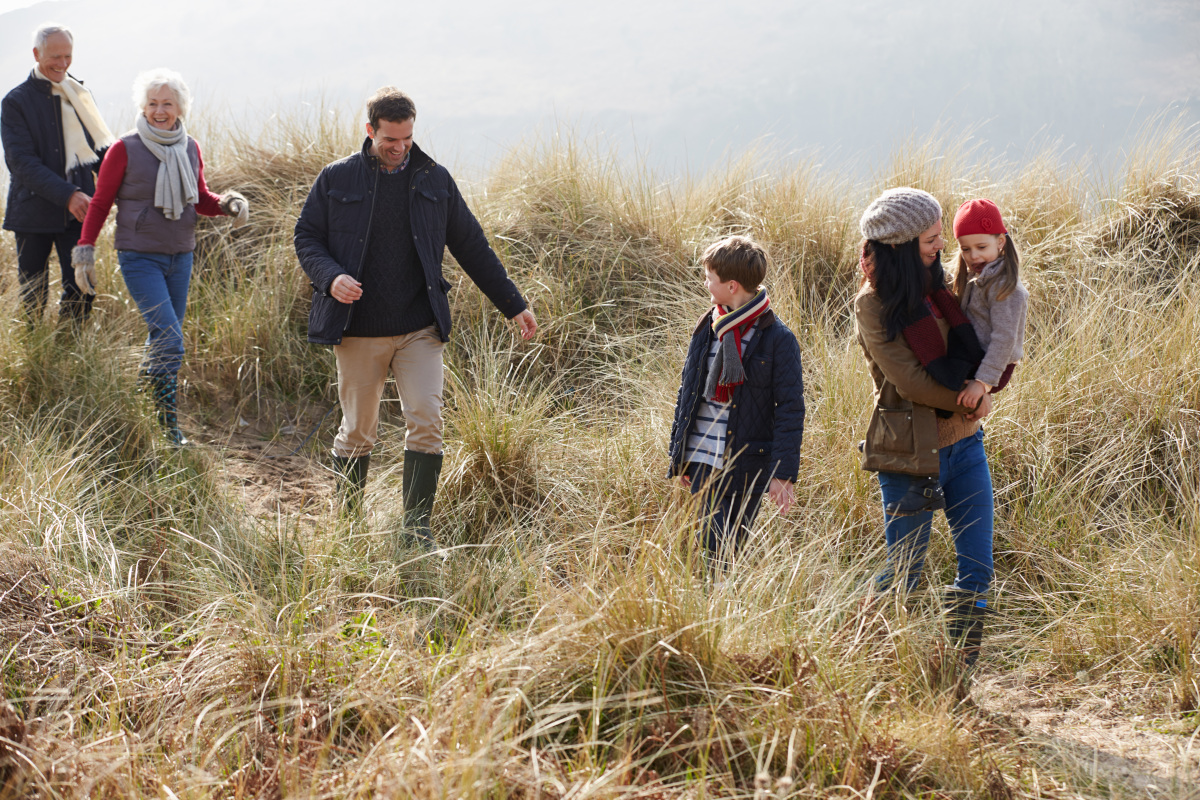 Familie met meerdere generaties wandelend door de duinen