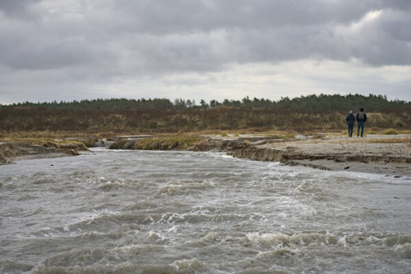 een geul met zeewater loopt dwars door het strand