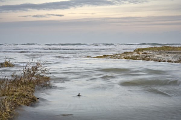 een geul zeewater doorkruist het strand