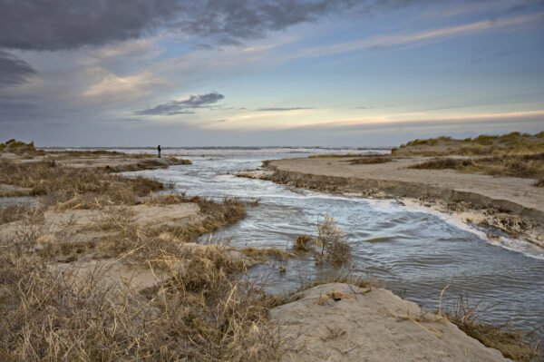 een geul zeewater doorkruist het strand