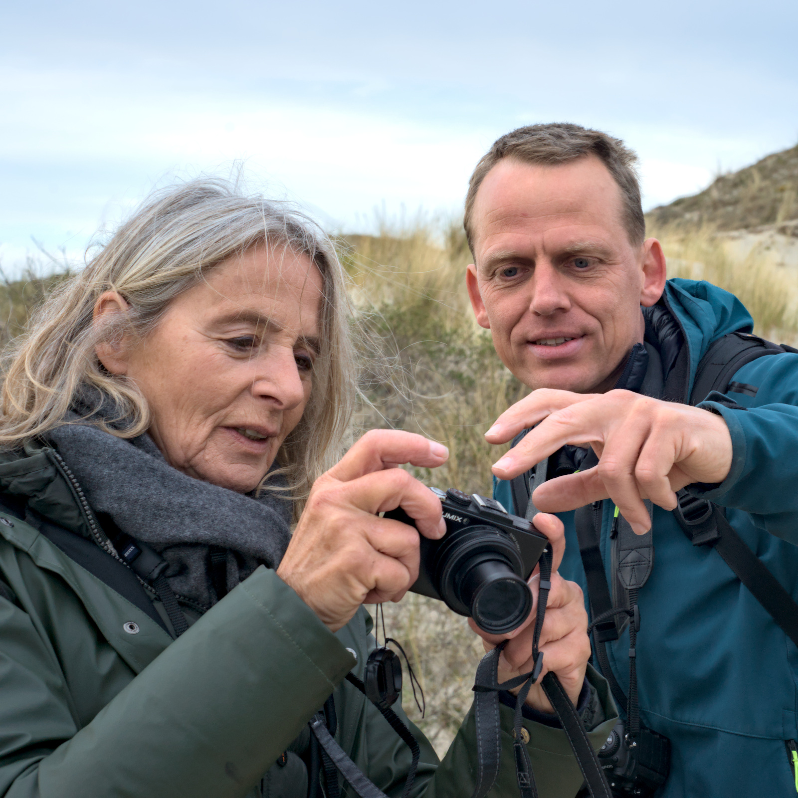 man en vrouw kijken naar een camera