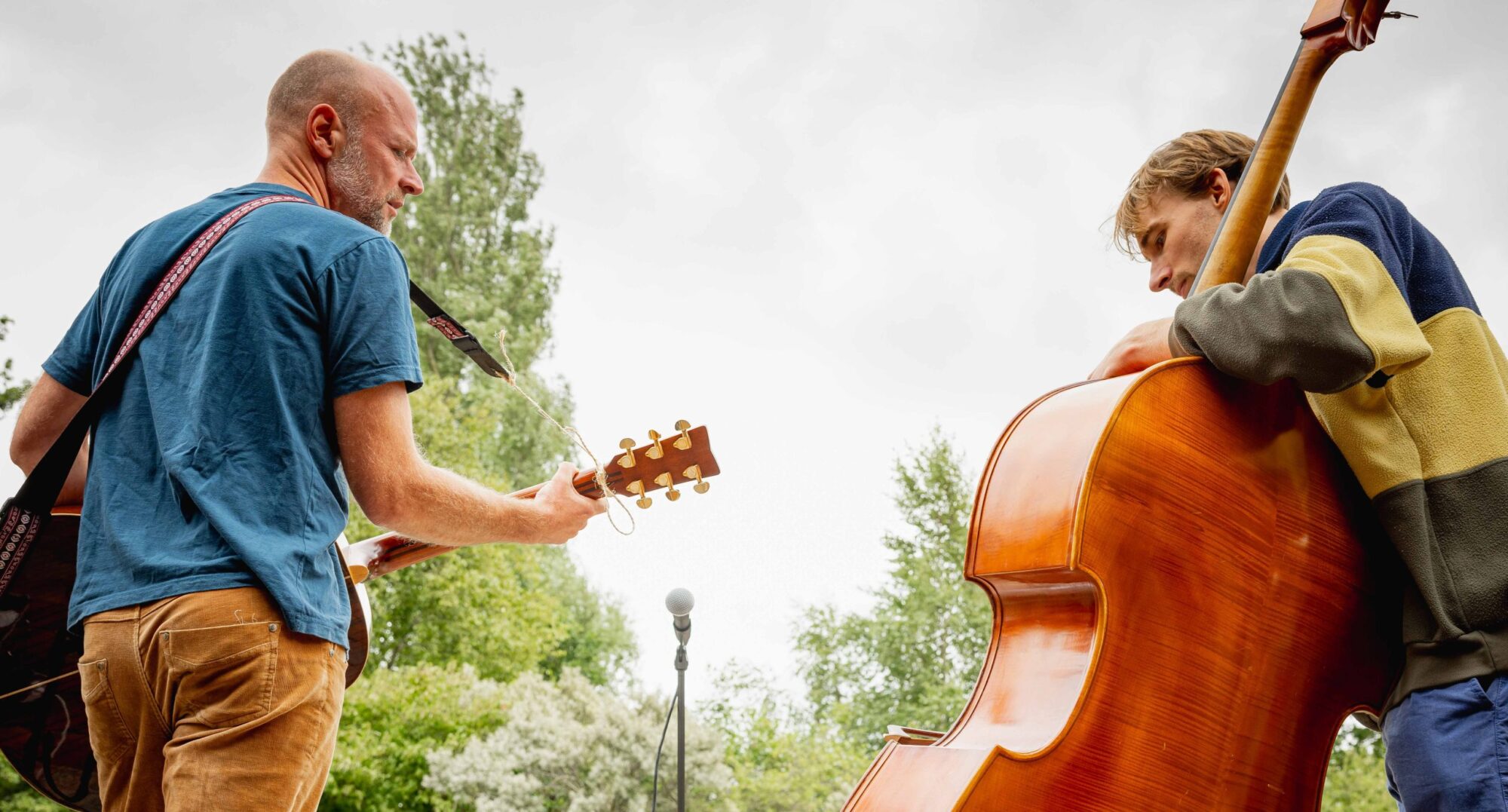 gitarist en bassist op podium in openlucht