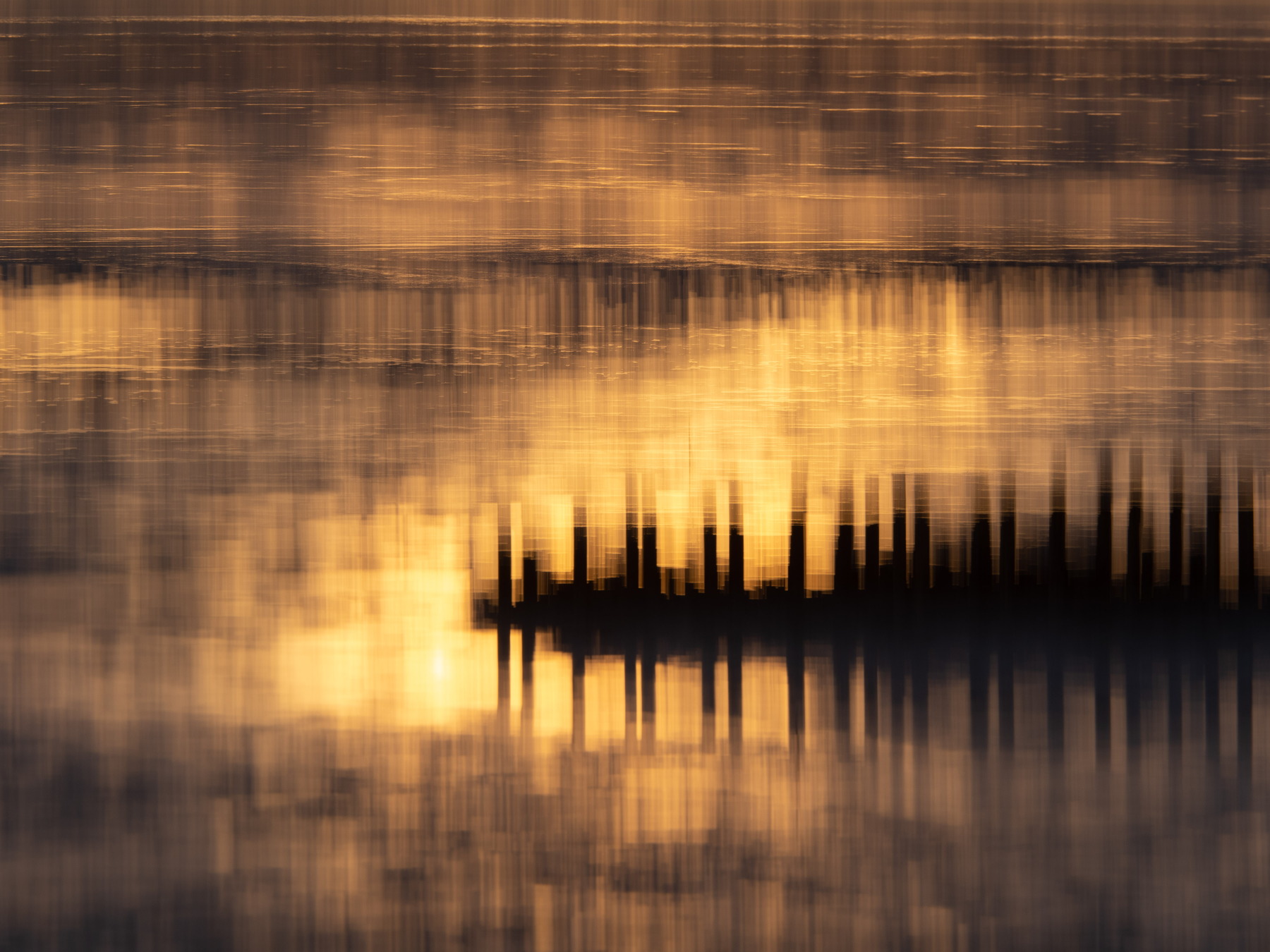 warm dromerig beeld van paaltjes in het water met Intentional Camera Movement
