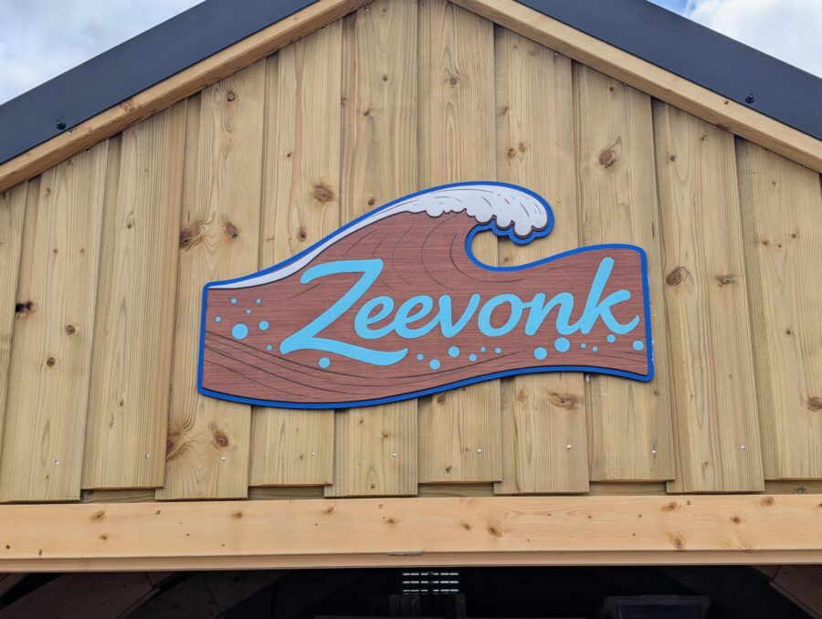 Houten bord in de vorm van een golf met opschrift Zeevonk